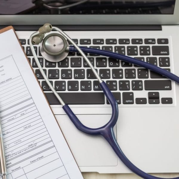 Medical history form with stethoscope on laptop.